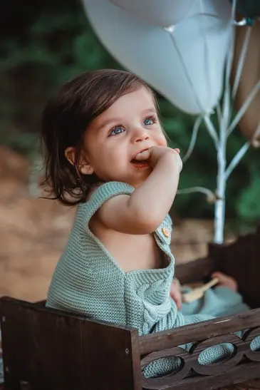 הילד יושב בין שיבולים וצוחק