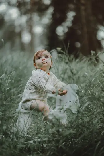 הילדה חוגגת שנה עם כתר זהב בטבע
