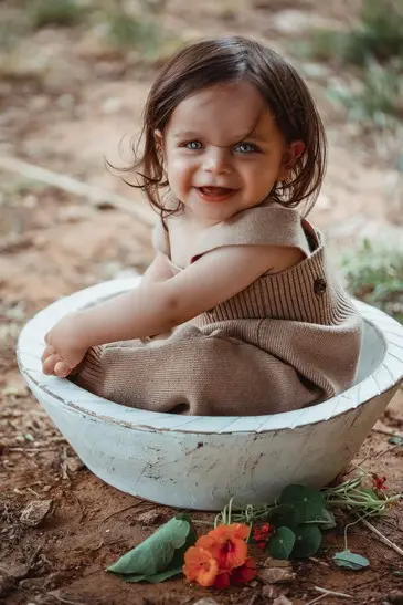 תינוקת ביישנית בצילומי גיל שנה בטבע